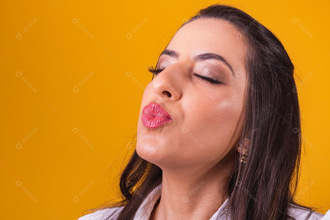 Mulher bonita com lábios franzidos mandando beijo com espaço para texto.