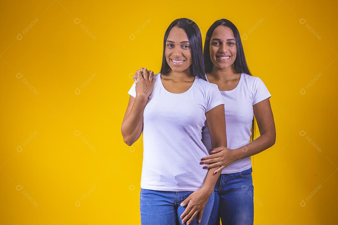 lindas irmãs gêmeas olhando para a câmera sorrindo