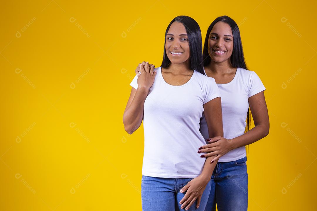 lindas irmãs gêmeas olhando para a câmera sorrindo