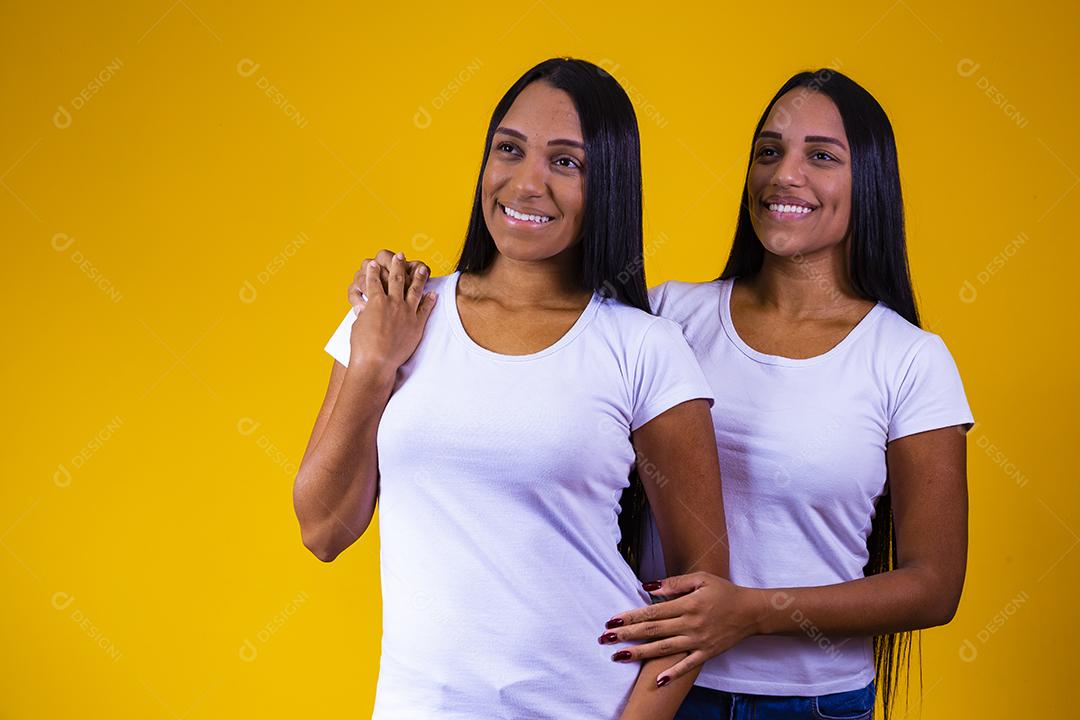 lindas irmãs gêmeas olhando para a câmera sorrindo