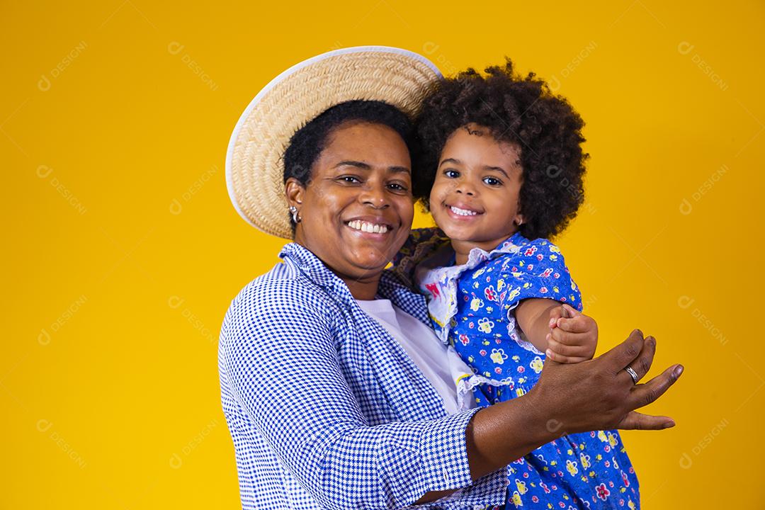 Afro mãe e filha vestidas para festa junina.