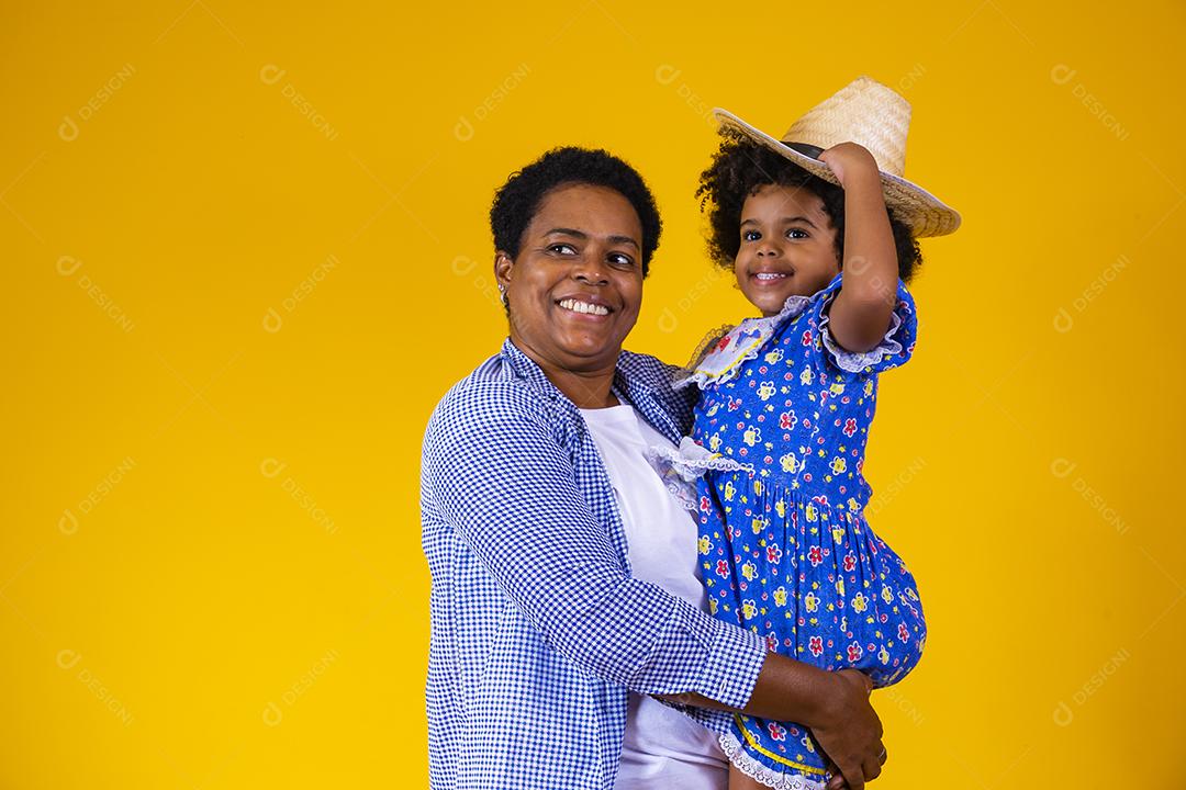 Afro mãe e filha vestidas para festa junina.