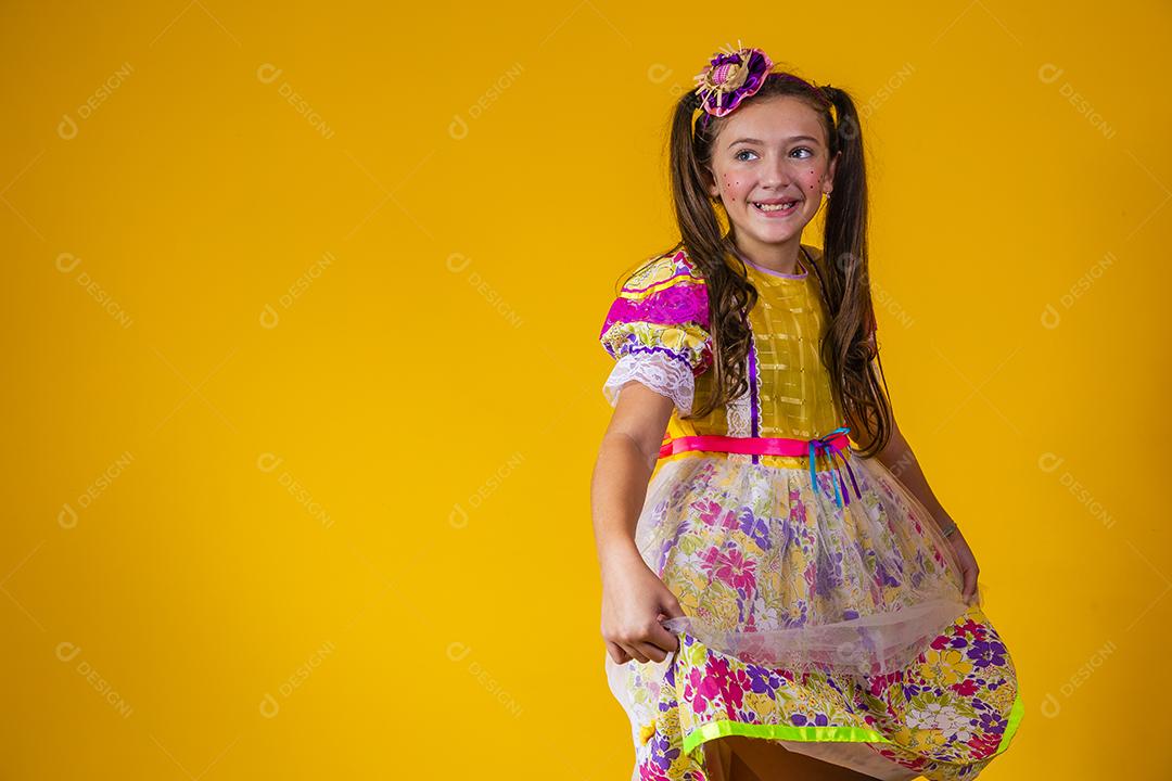 Criança com roupas típicas da famosa festa brasileira chamada Festa Junina em comemoração ao São João