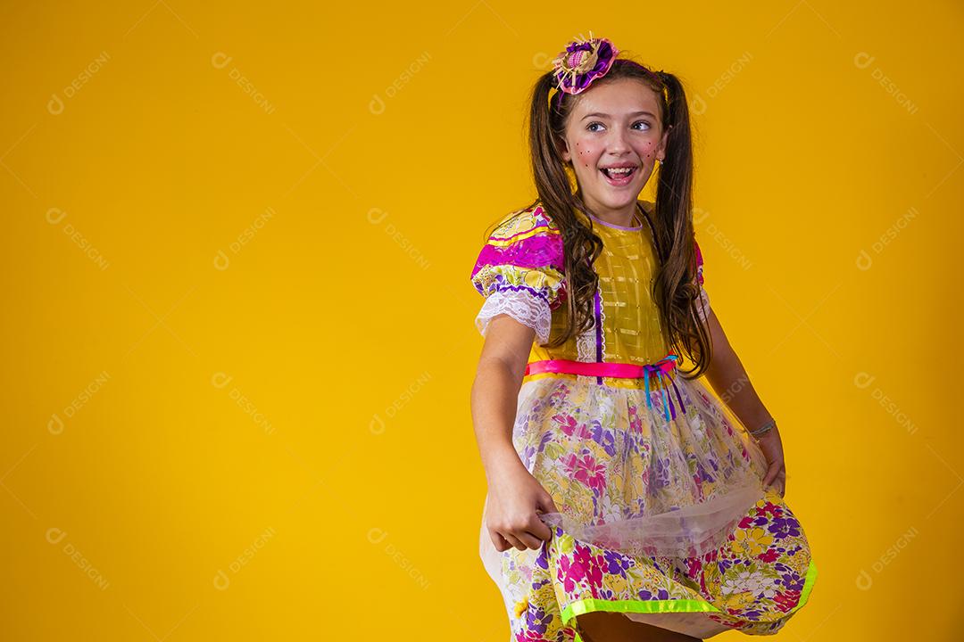 Criança com roupas típicas da famosa festa brasileira chamada Festa Junina em comemoração ao São João