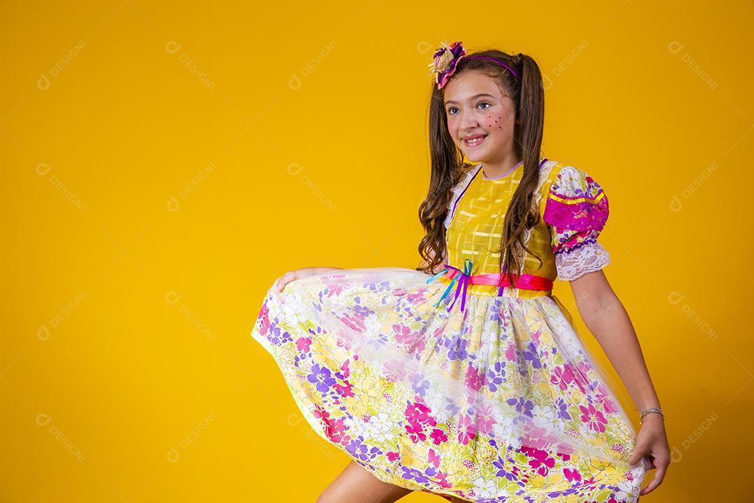 Criança com roupas típicas da famosa festa brasileira chamada Festa Junina em comemoração ao São João