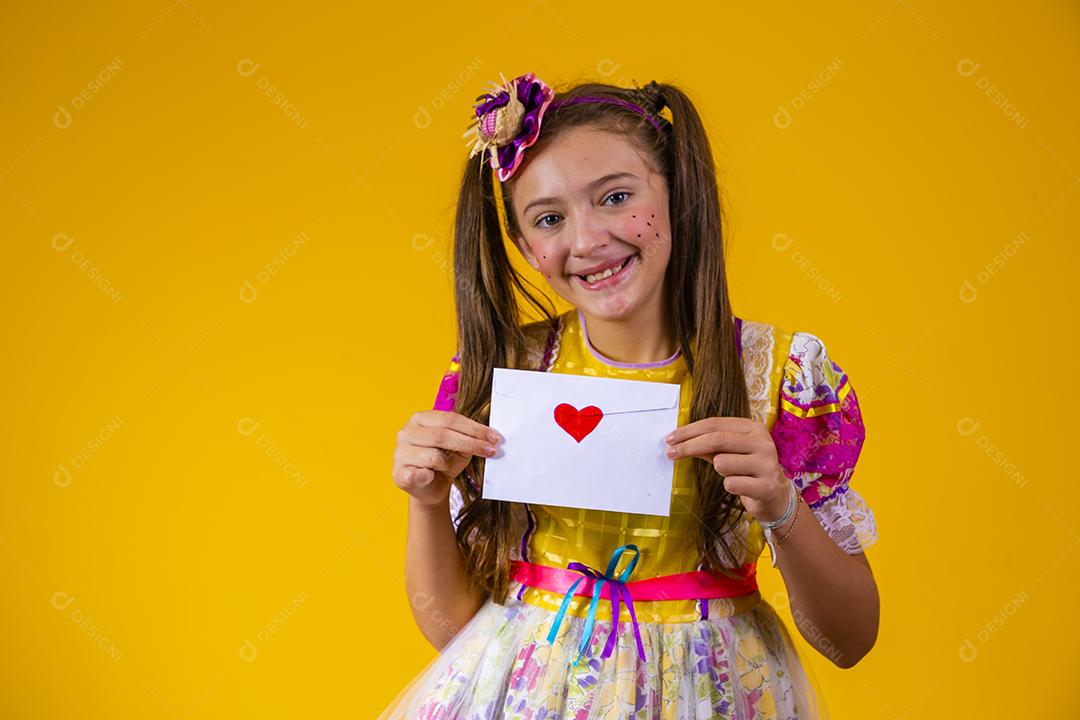 Festa Junina no Brasil, jovem segurando uma carta de amor no festival brasileiro de junho vestindo fantasia.