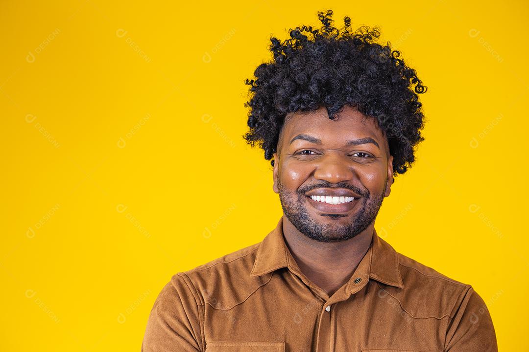 Retrato de bonitão africano sorrindo olhando para a câmera sobre parede amarela. Estudante confiante ou jovem empresário.