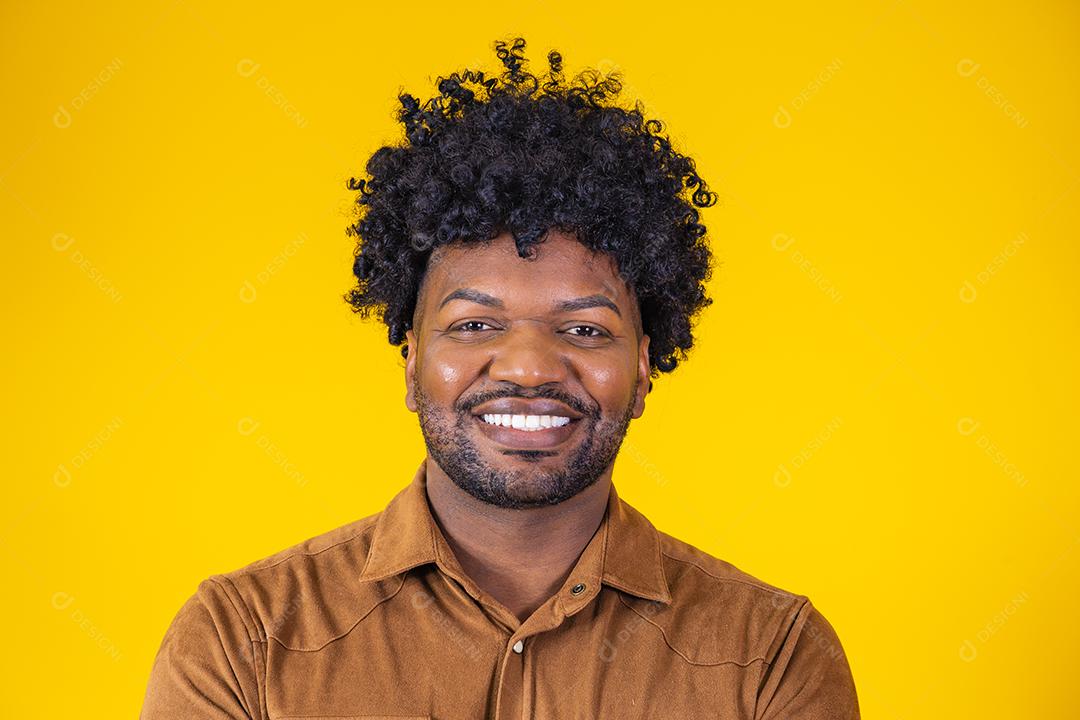 Retrato de bonitão africano sorrindo olhando para a câmera sobre parede amarela. Estudante confiante ou jovem empresário.