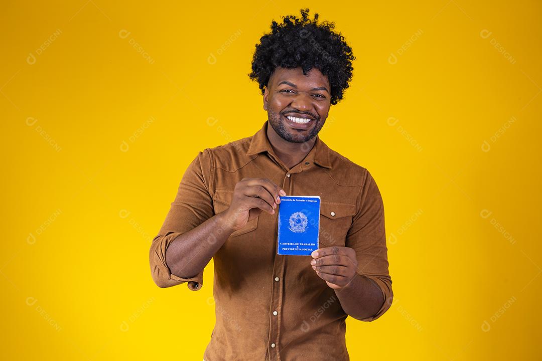 Homem afro brasileiro com trabalho documental e segurança social, (Carteira de Trabalho e Previdência Social) em fundo amarelo