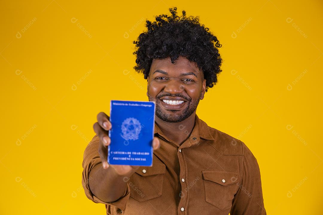 Homem afro brasileiro com trabalho documental e segurança social, (Carteira de Trabalho e Previdência Social) em fundo amarelo