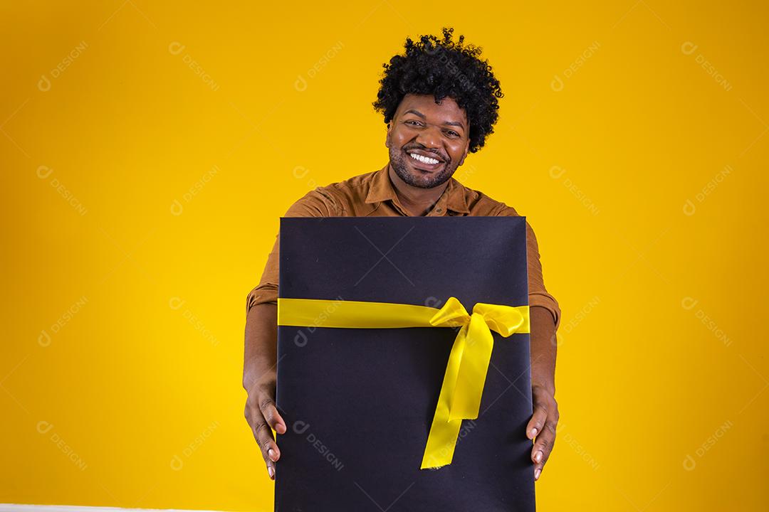 Homem de pele escura feliz e encantador de bom humor com presente de dia dos namorados isolado