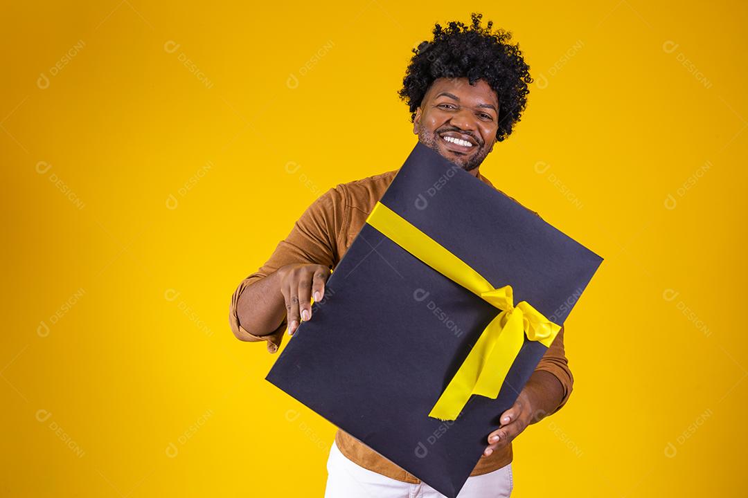Homem de pele escura feliz e encantador de bom humor com presente de dia dos namorados isolado