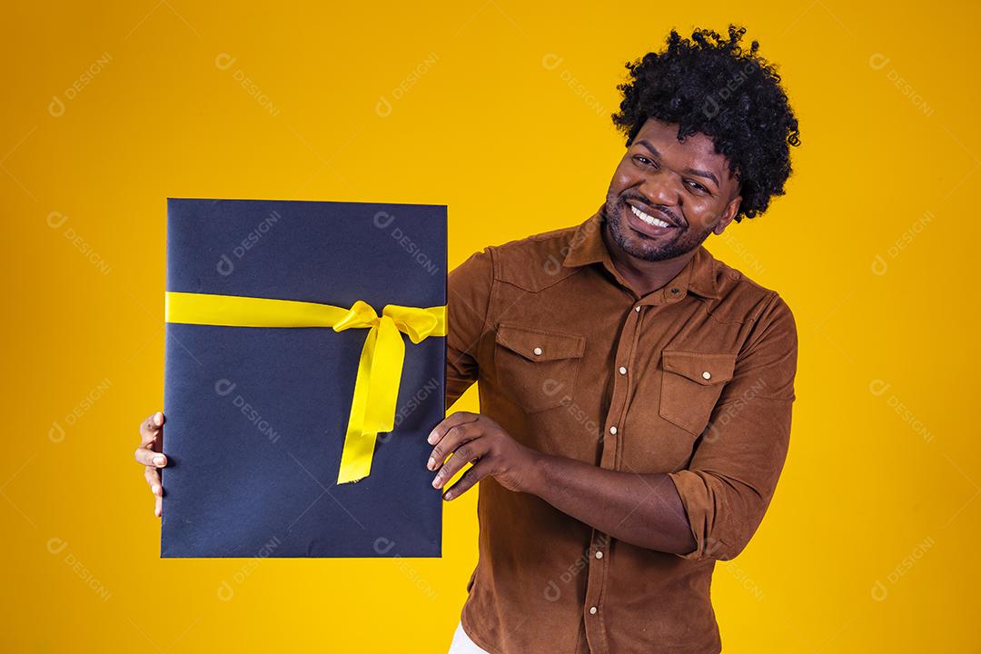 Homem de pele escura feliz e encantador de bom humor com presente de dia dos namorados isolado