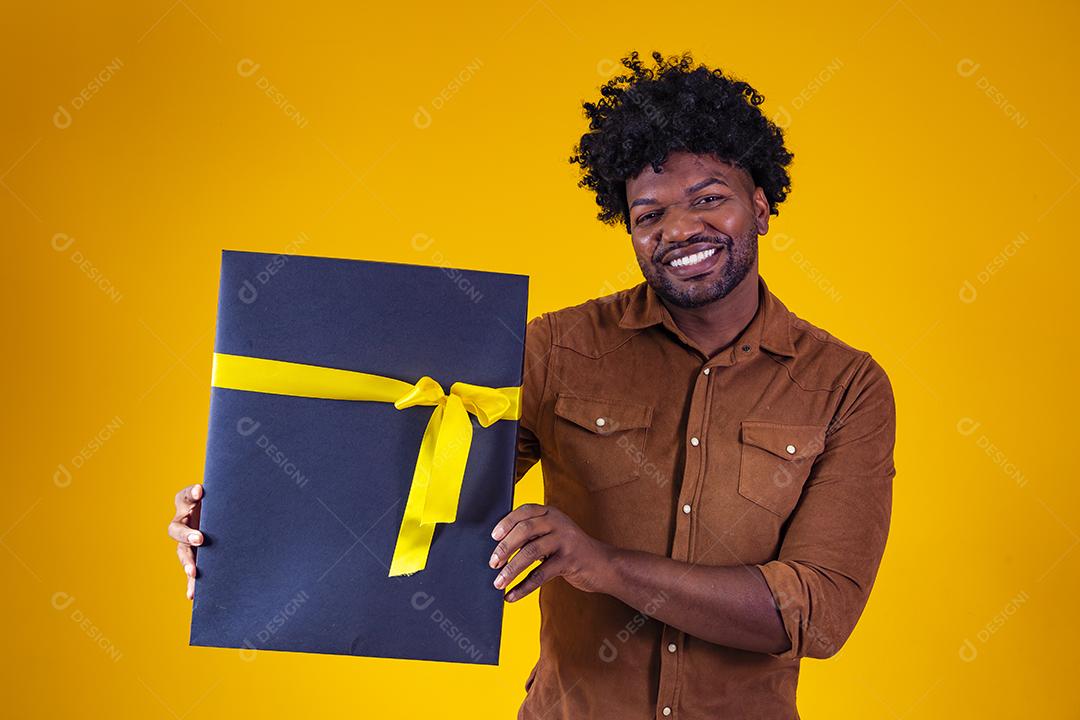 Homem de pele escura feliz e encantador de bom humor com presente de dia dos namorados isolado