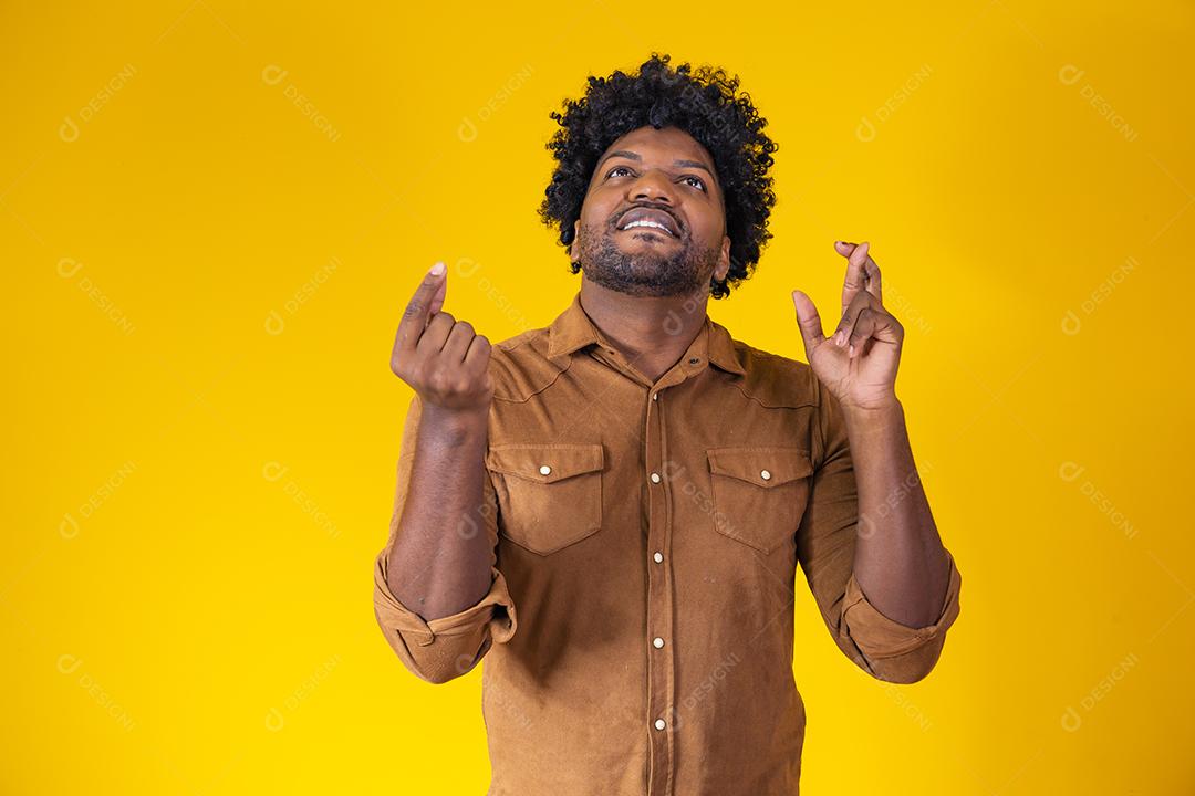 Eu tenho que vencer. Alegre jovem morena aperta os dentes, levanta os dedos cruzados, faz um desejo desejável