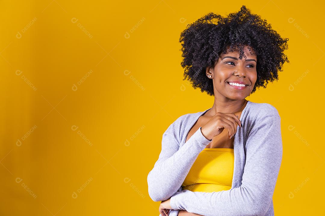 Linda mulher afro-americana olhando para a câmera. Retrato de jovem alegre com penteado afro