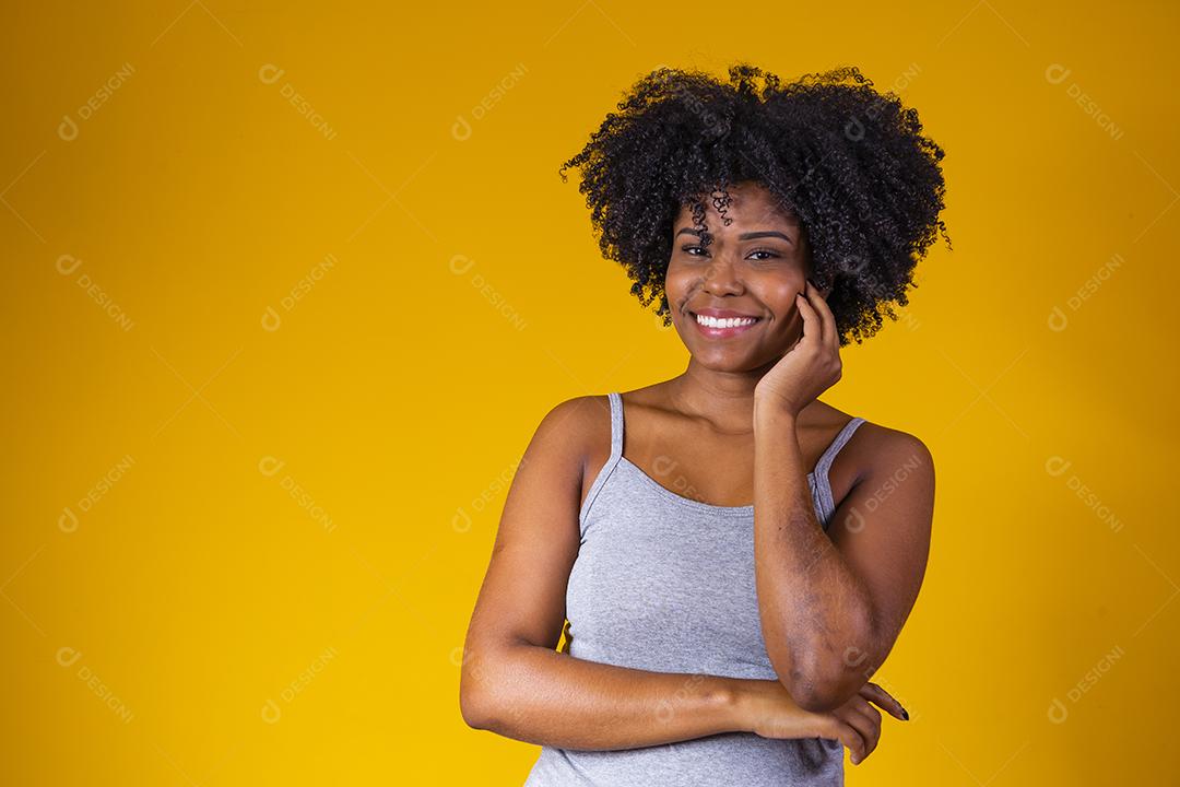 Linda mulher afro-americana olhando para a câmera. Retrato de jovem alegre com penteado afro