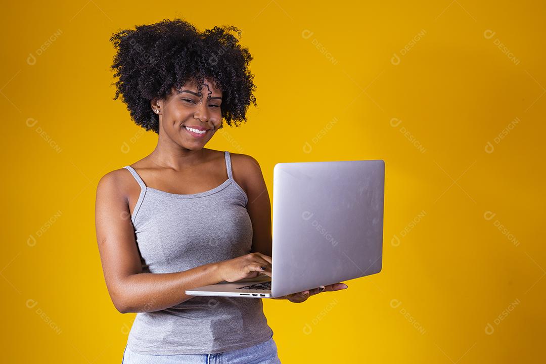 A africana roupas móveis isoladas computador portátil sobre fundo amarelo