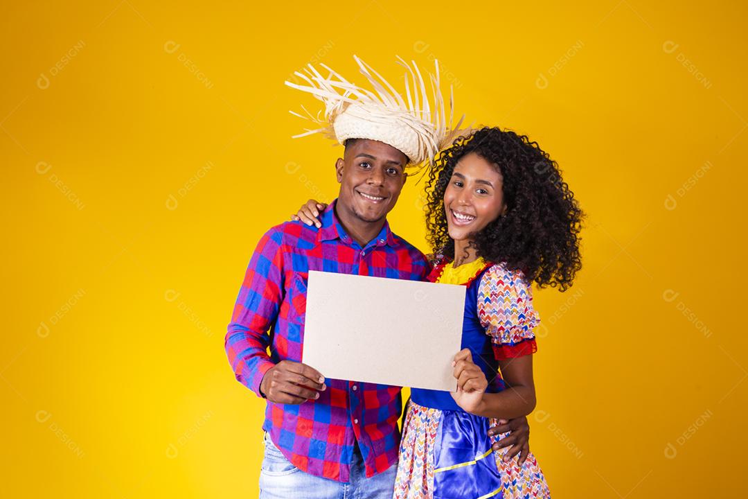 Casal brasileiro vestindo roupas tradicionais para a Festa Junina da