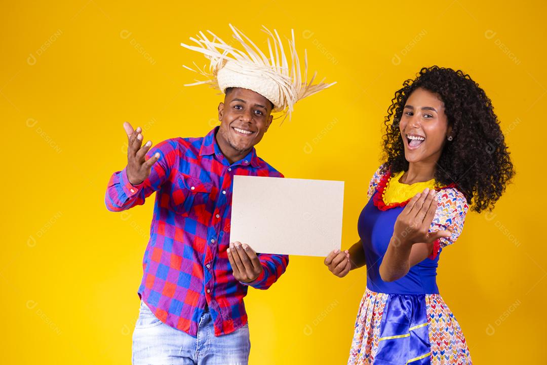 Casal brasileiro vestindo roupas tradicionais para a Festa Junina da