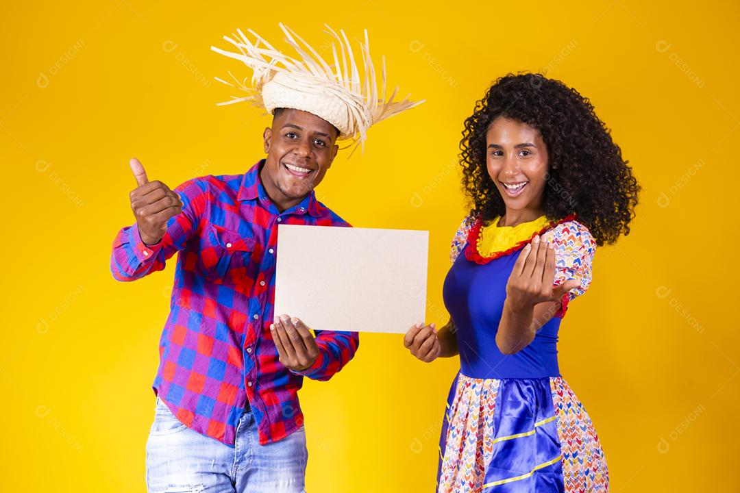 Casal brasileiro vestindo roupas tradicionais para a Festa Junina da