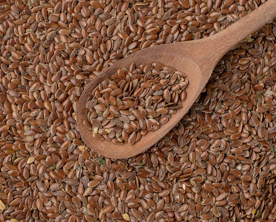 brown flax seeds in a wooden spoon.