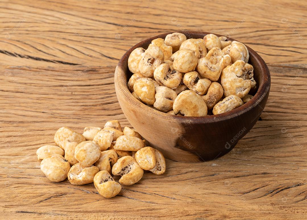 Canjica, canjica ou pipoca de milho branco, pipoca doce em uma tigela sobre mesa de madeira