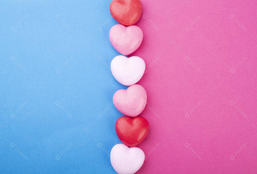 Sabonetes coloridos em forma de coração sobre fundo rosa e azul