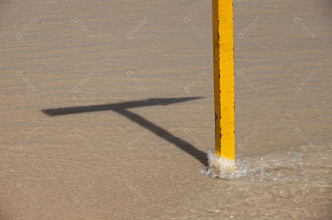 Sinal amarelo sobre as ondas.