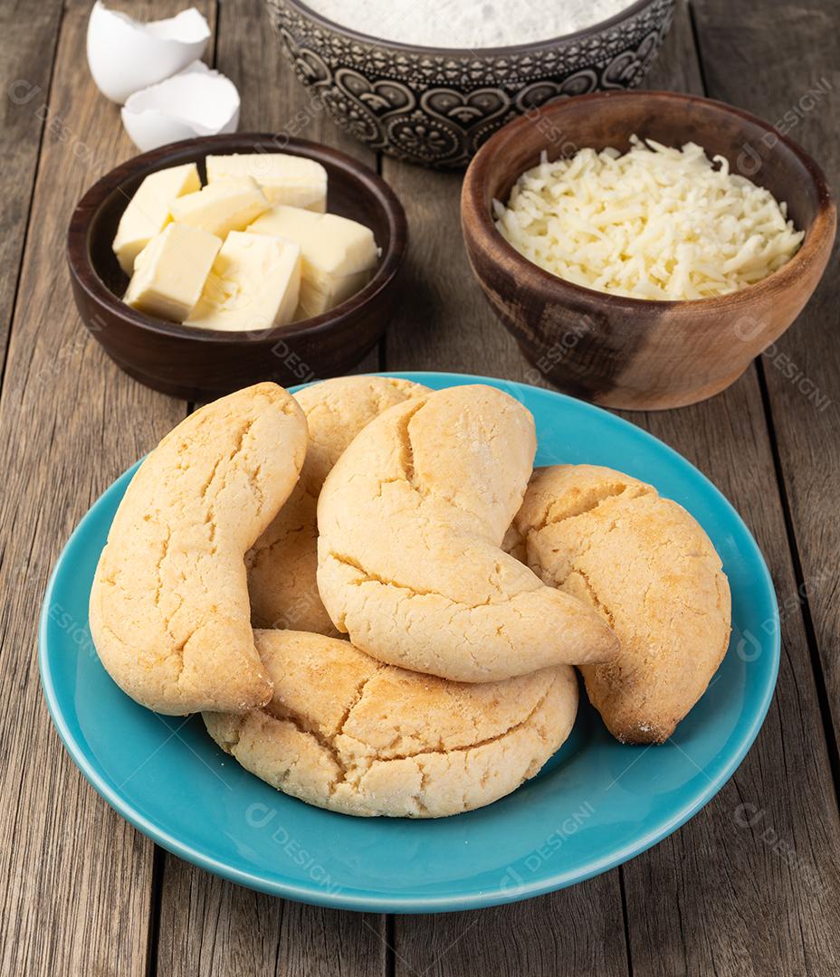 Chipas, pão de queijo típico sul-americano sobre mesa de madeira com ingredientes.