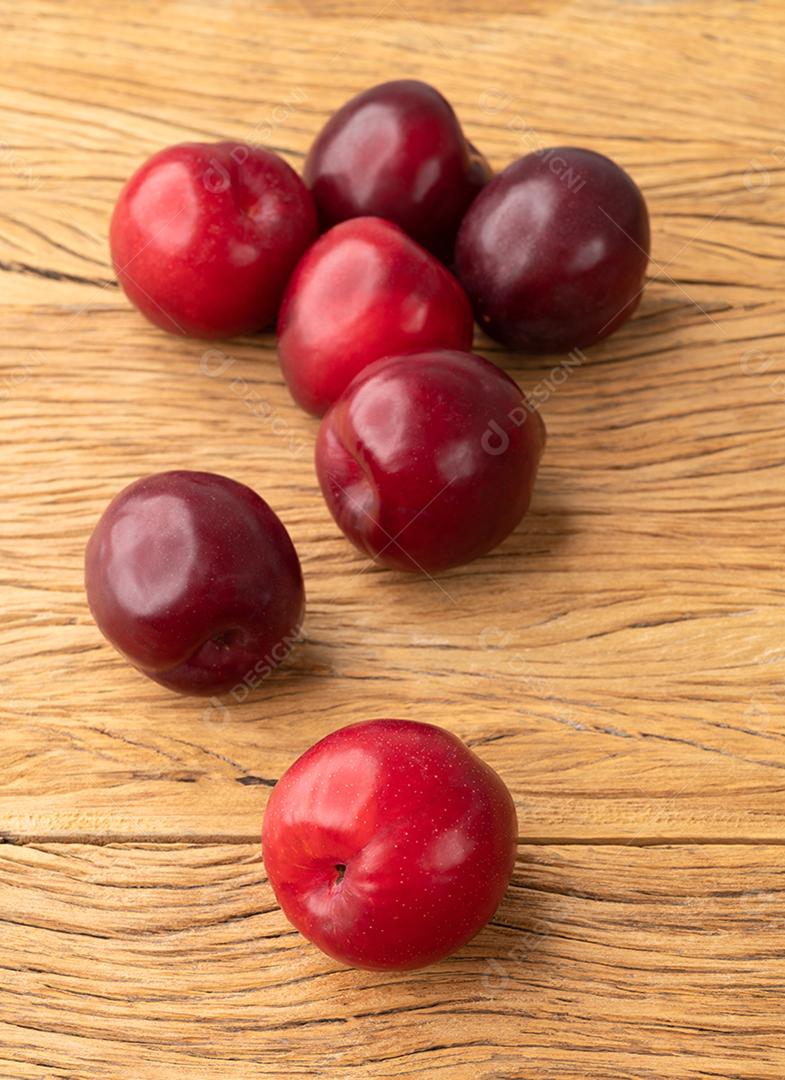 Um grupo de ameixas sobre a mesa de madeira.