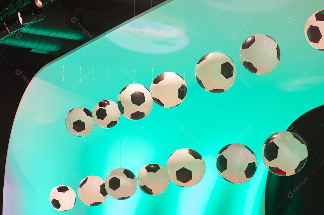 Bolas de futebol penduradas sobre luz verde