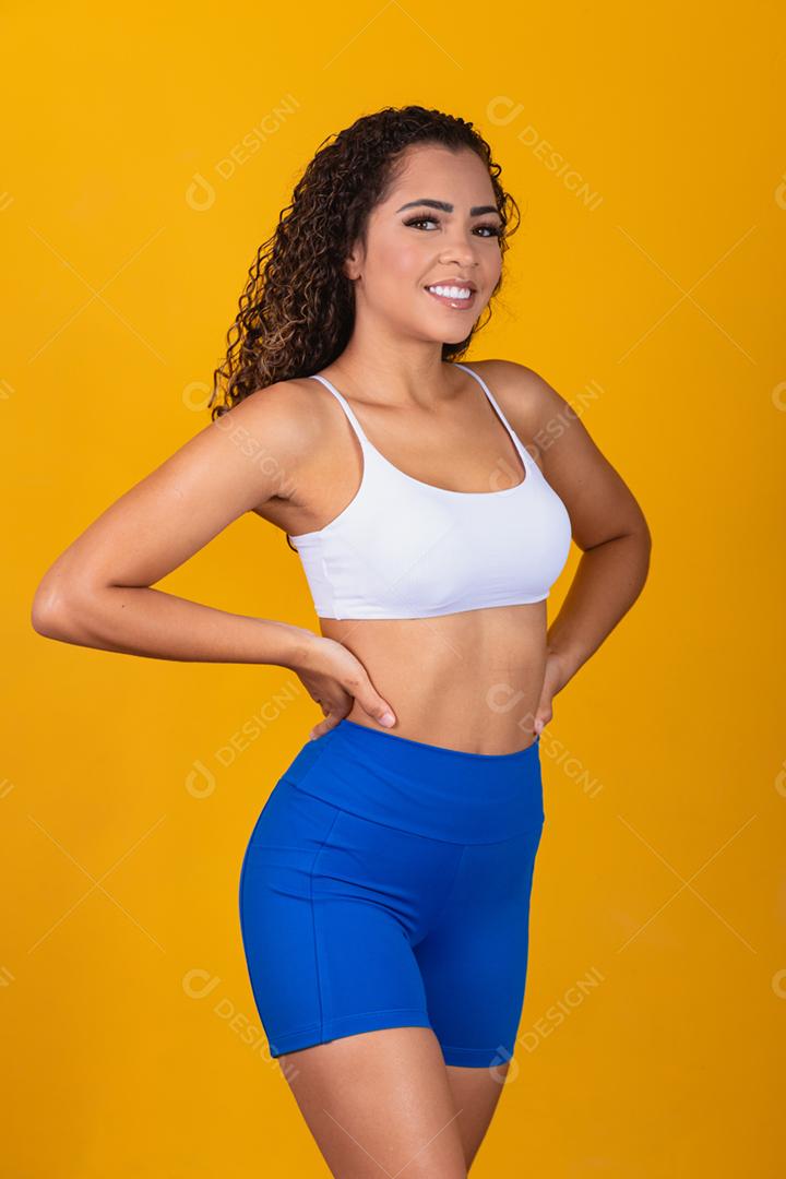 Linda jovem afro com roupa de fitness sorrindo olhando para