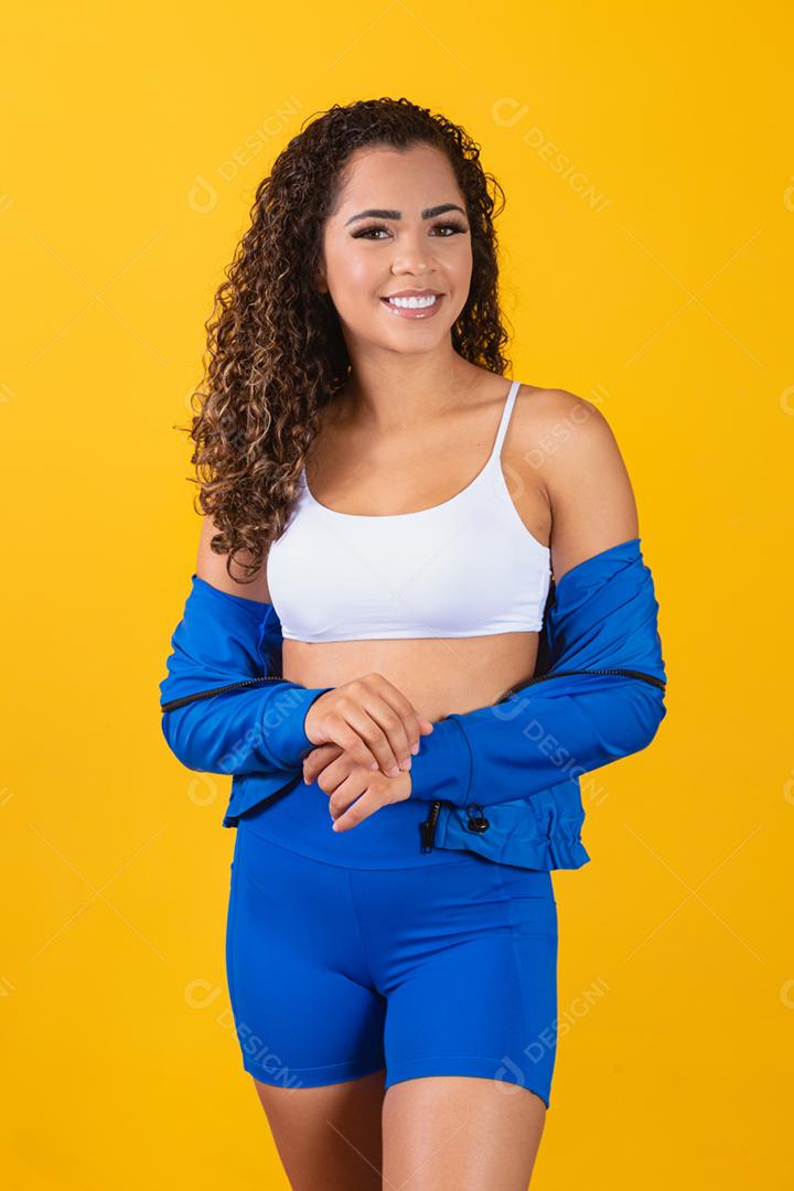 Linda jovem afro com roupa de fitness sorrindo olhando para