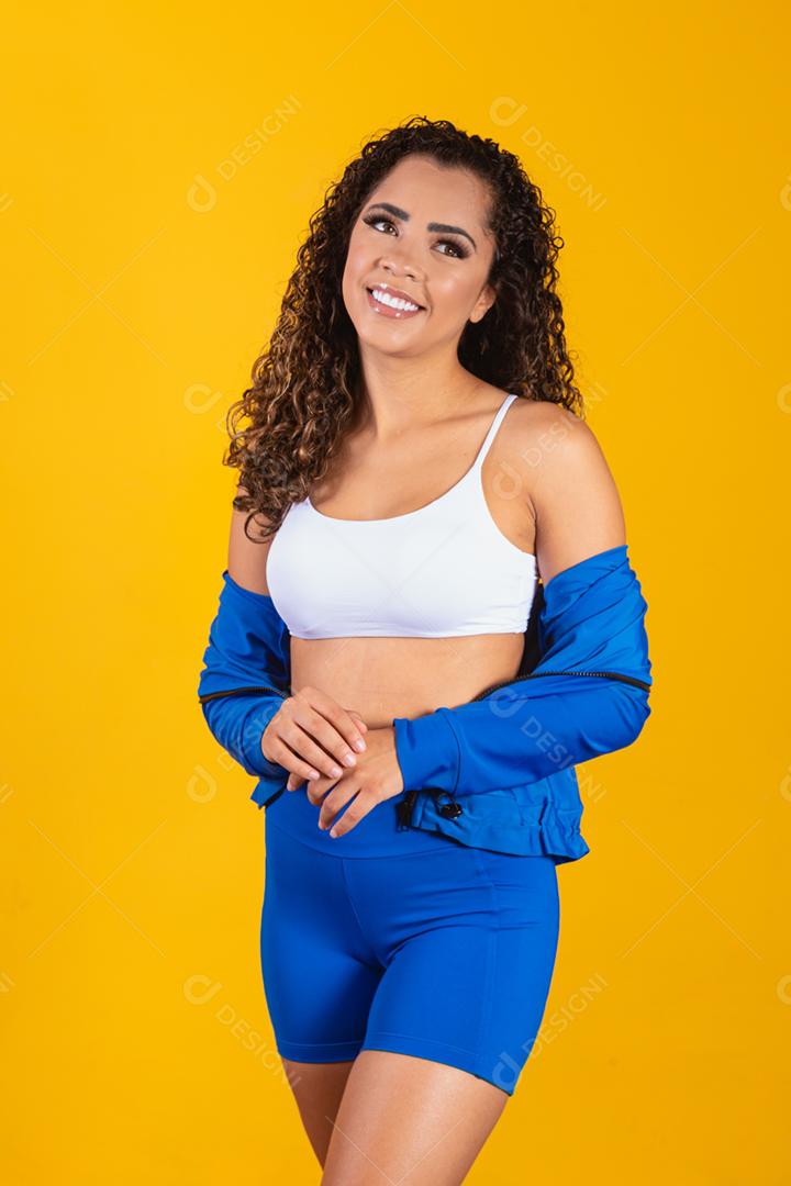 Linda jovem afro com roupa de fitness sorrindo olhando para