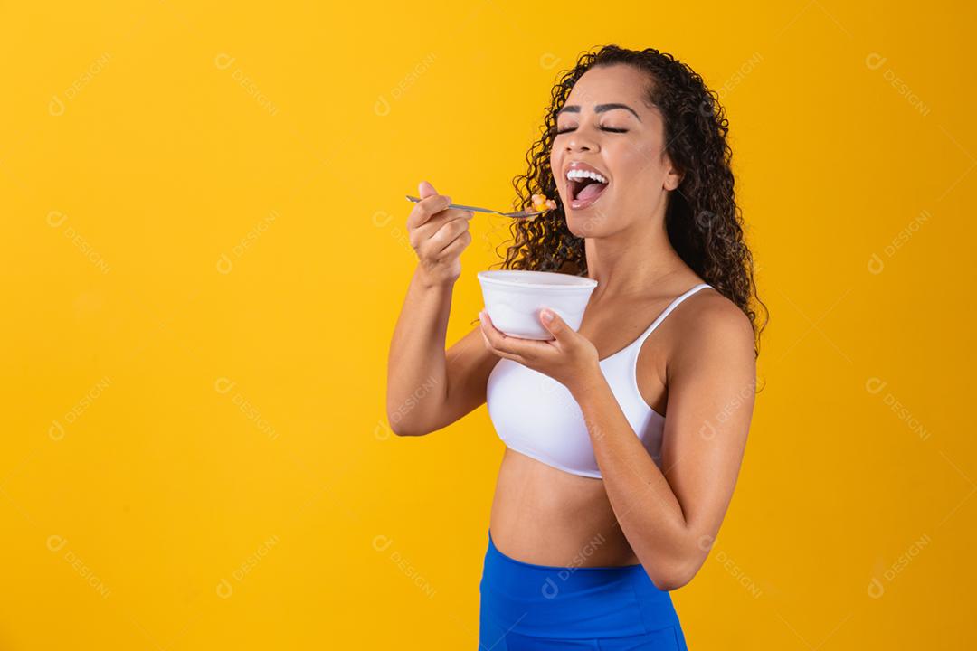 jovem mulher afro saudável comendo salada de frutas.