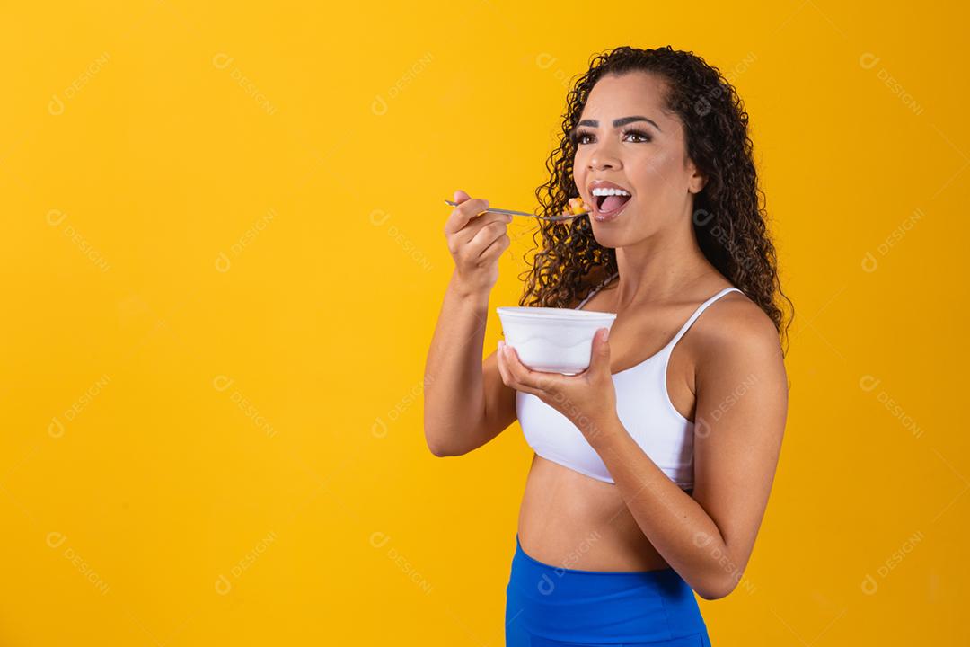 jovem mulher afro saudável comendo salada de frutas.