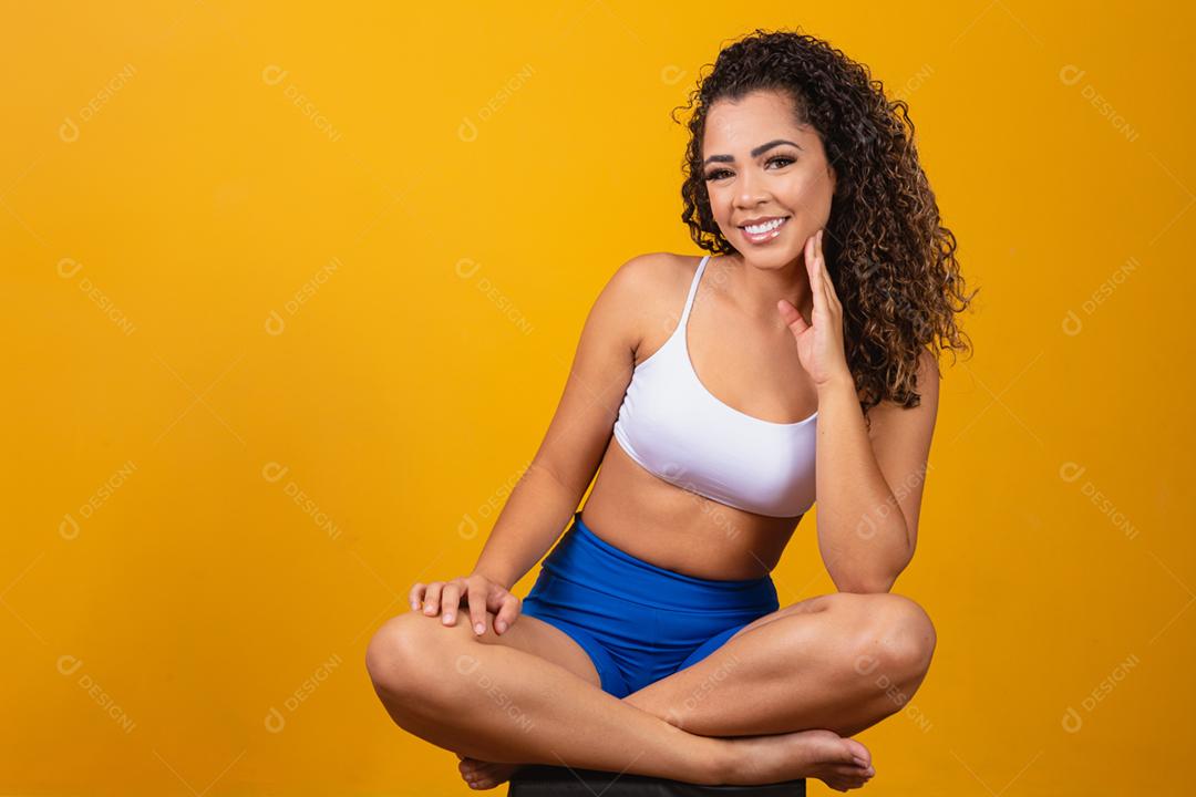 Linda jovem afro com roupa de fitness sorrindo olhando para