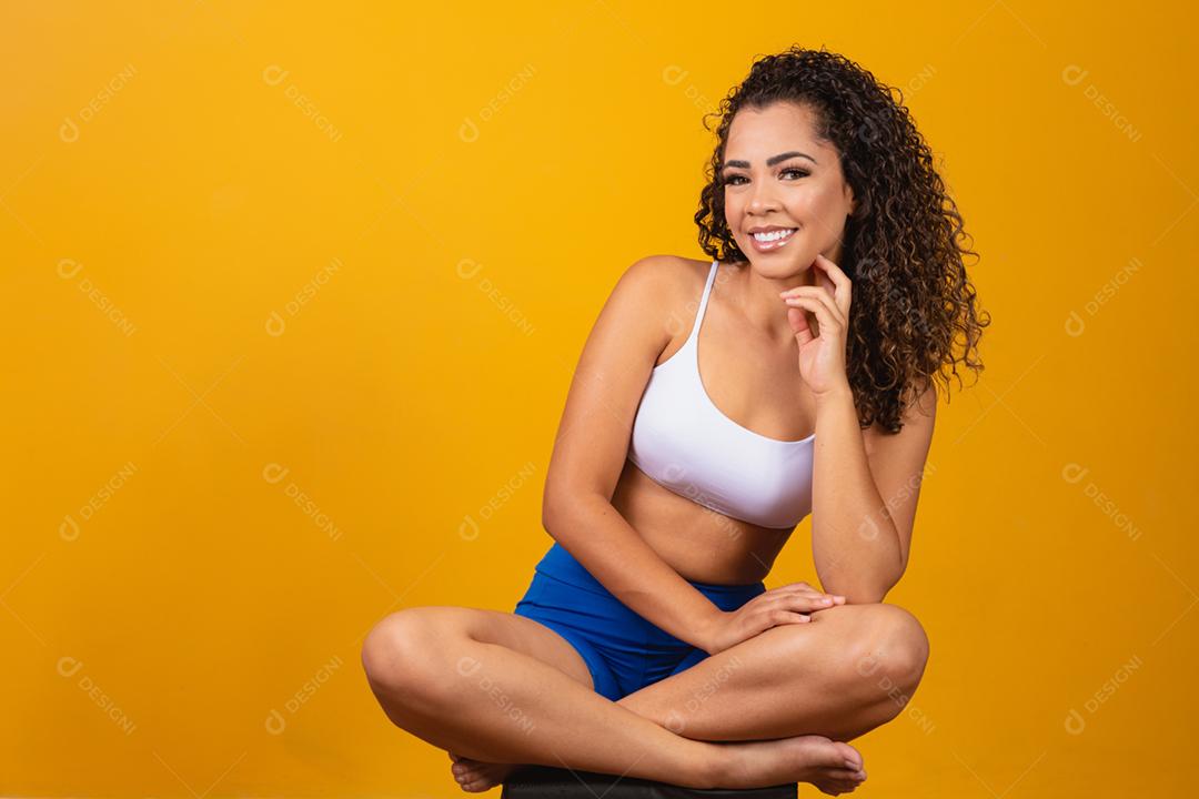 Linda jovem afro com roupa de fitness sorrindo olhando para