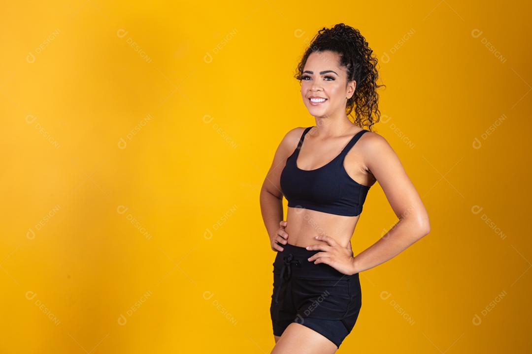Jovem afro em roupas de ginástica, sorrindo para a câmera. mulher com sc