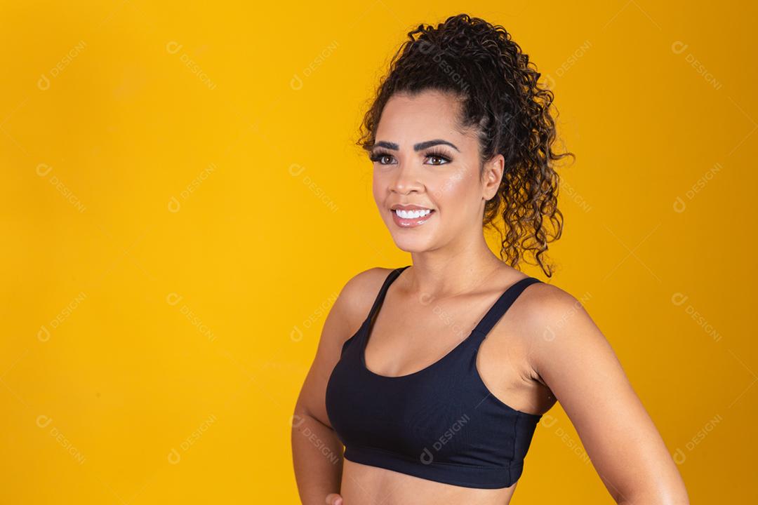 Jovem afro em roupas de ginástica, sorrindo para a câmera. mulher com sc