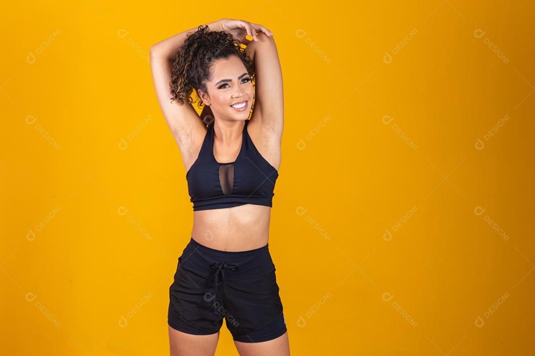 Jovem afro que se estende sobre fundo amarelo com espaço para