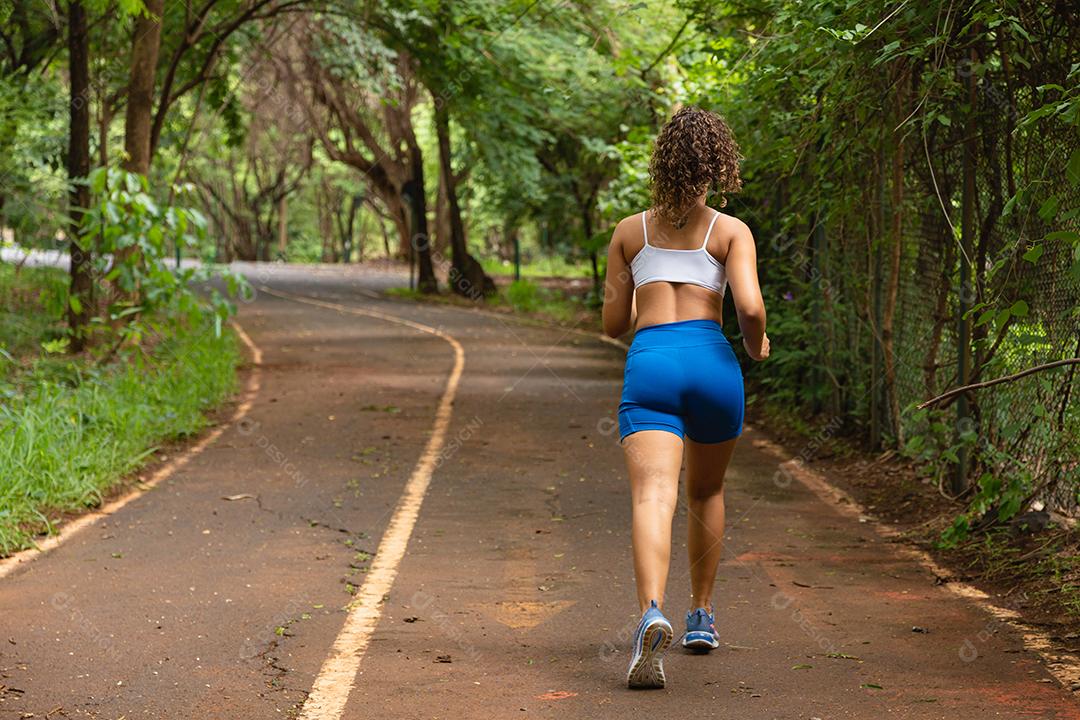 Mulher correndo no parque.