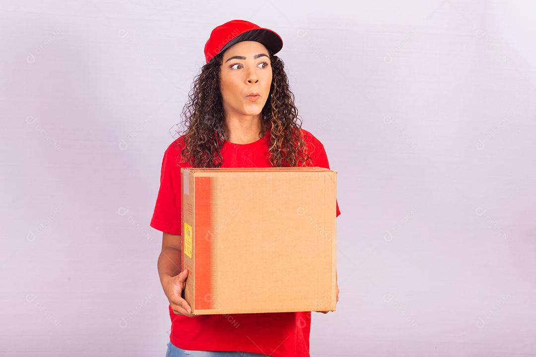 mulher excitada com uma caixa de papelão vestida como entregadora