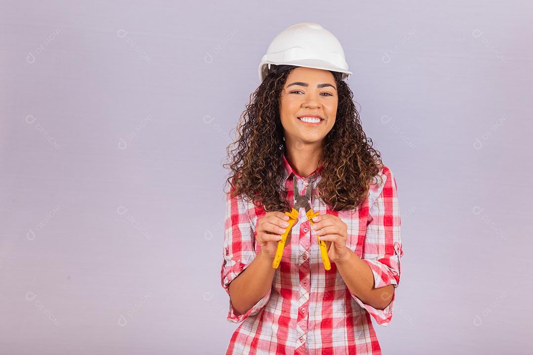 Técnica feminina. Mulher eletricista em fundo branco