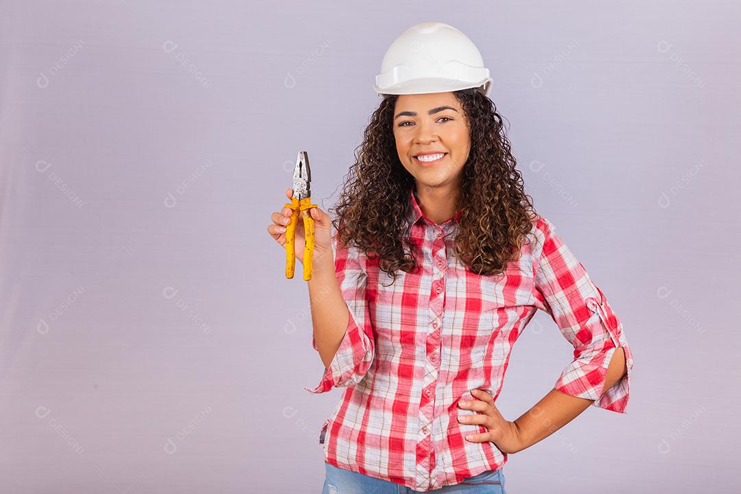 Técnica feminina. Mulher eletricista em fundo branco