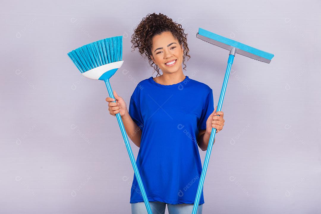 Mulher de limpeza segurando um rodo e uma vassoura. conceito de limpeza de casa