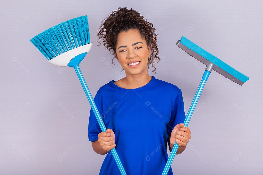 Mulher de limpeza segurando um rodo e uma vassoura. conceito de limpeza de casa