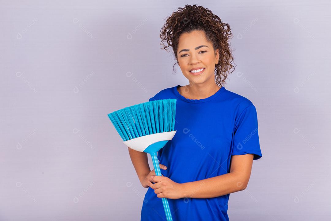 Mulher dona de casa. Limpador. Jovem segurando a vassoura em fundo branco