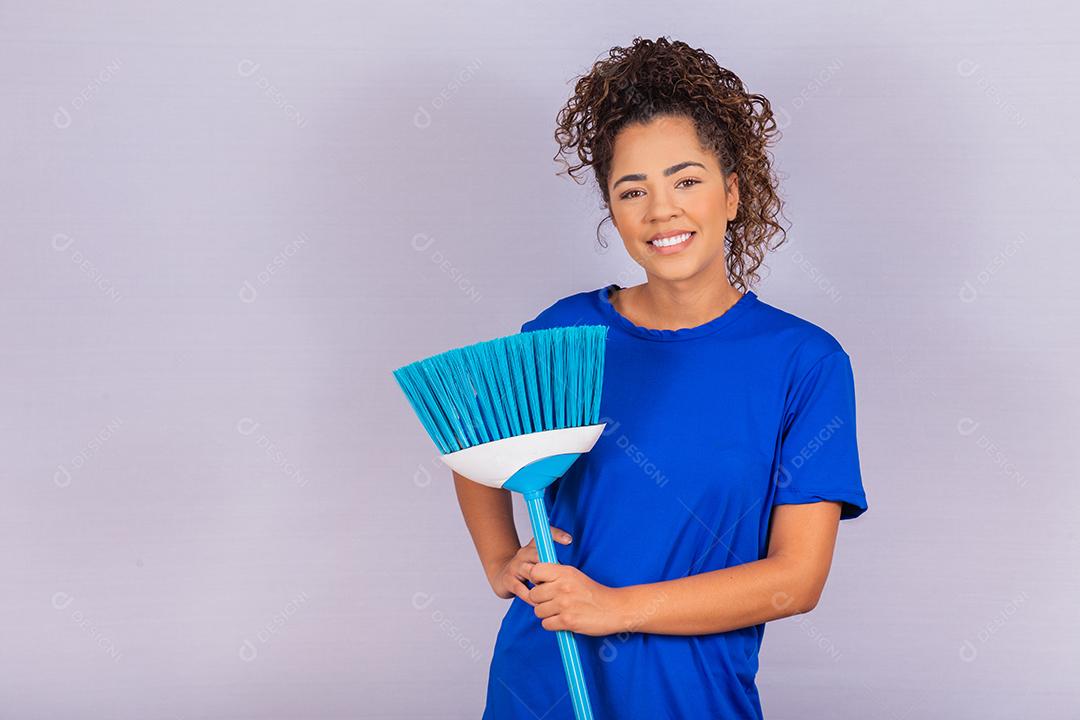 Mulher dona de casa. Limpador. Jovem segurando a vassoura em fundo branco